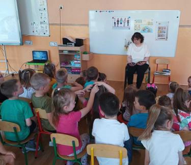 Nauczyciel bibliotekarz czyta dzieciom