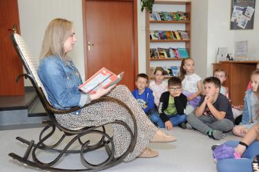 Nauczyciel bibliotekarz czyta dzieciom 