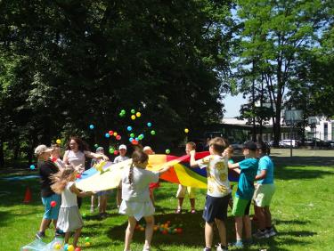 Impreza czytelnicza dla dzieci zorganizowana w  scenerii parku otaczającego Pałac Sroczyńskich