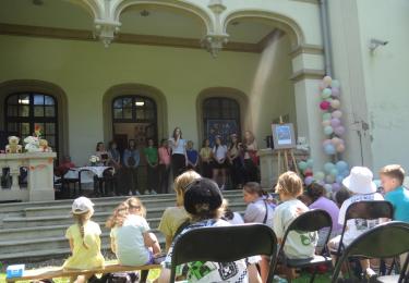 Impreza czytelnicza dla dzieci zorganizowana w  scenerii parku otaczającego Pałac Sroczyńskich