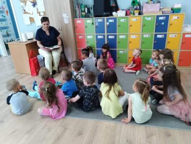 Nauczyciel bibliotekarz czyta dzieciom