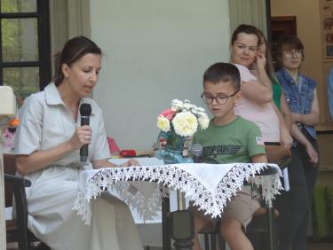 Impreza czytelnicza dla dzieci zorganizowana w  scenerii parku otaczającego Pałac Sroczyńskich