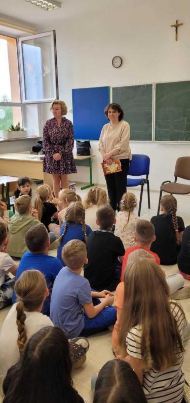 Nauczyciel bibliotekarz czyta dzieciom wiersze polskich autorów