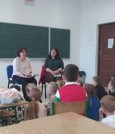 Nauczyciel bibliotekarz czyta dzieciom wiersze polskich autorów