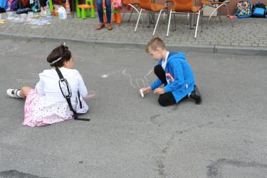 Dzieci malują kredą na parkingu